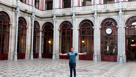 happy caucasian man spin in courtyard of nations of palacio da bolsa in porto