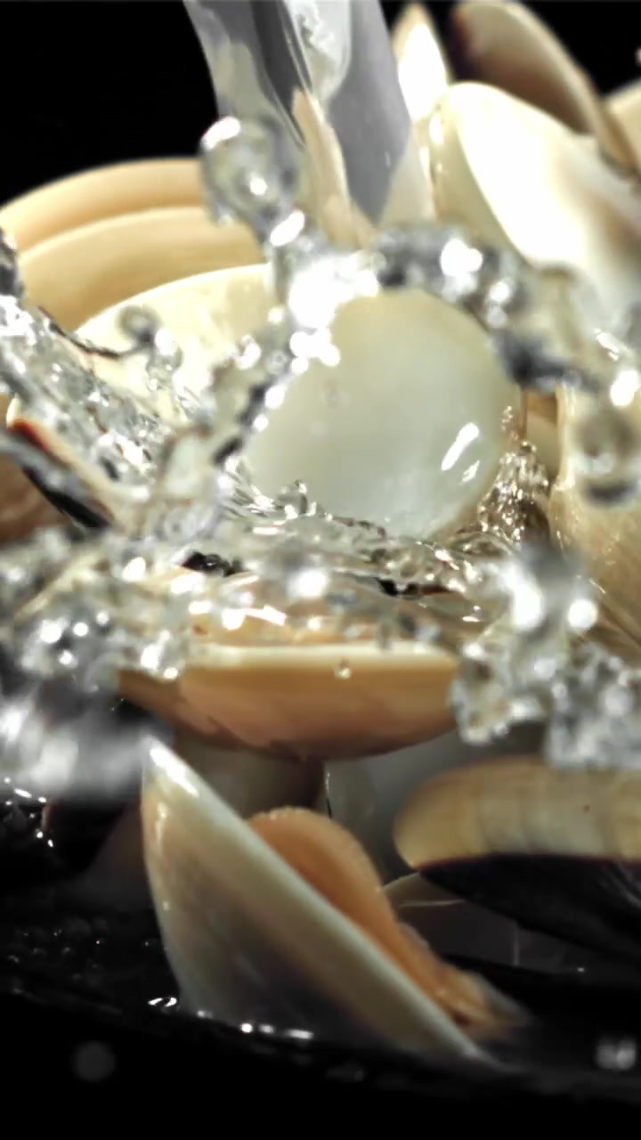 Acqua versata al rallentatore su vongole fresche