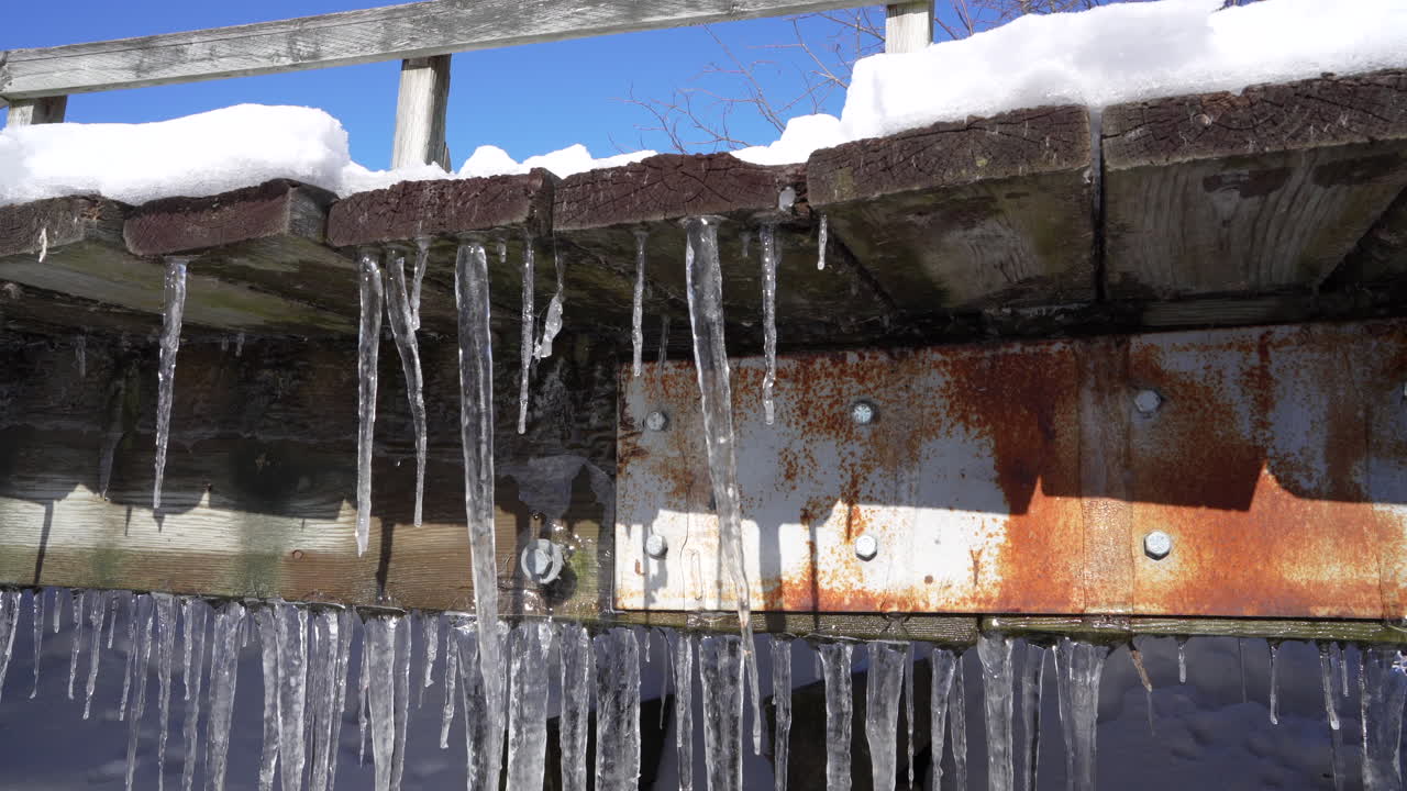 얼음 종유석이 있는 녹슨 다리