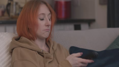 mujer aburrida viendo la televisión pasando entre los canales sentado en el sofá