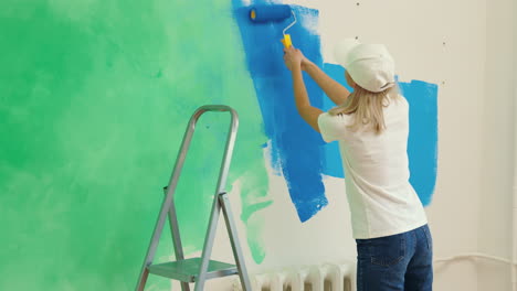 una mujer pintando una pared.