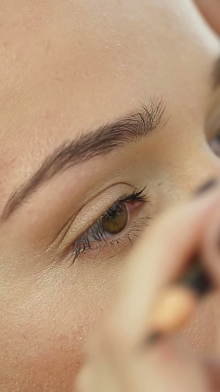 Permanent Makeup Eyebrows. Cosmetologist applying a special permanent makeup on eyebrows