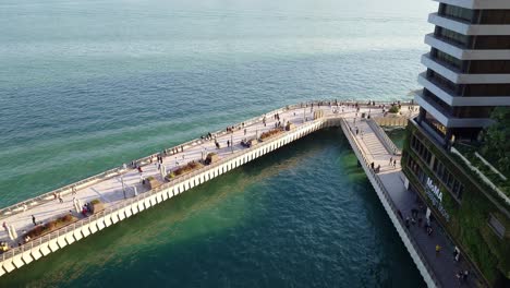 people walking over the promenade of avenue of stars at victoria harbour, hong kong, china