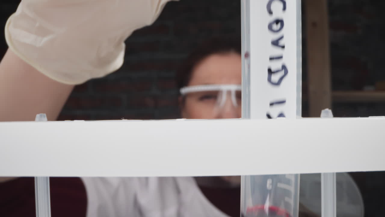 la enfermera pone el tubo con la sangre del paciente y etiqueta covid en el estante