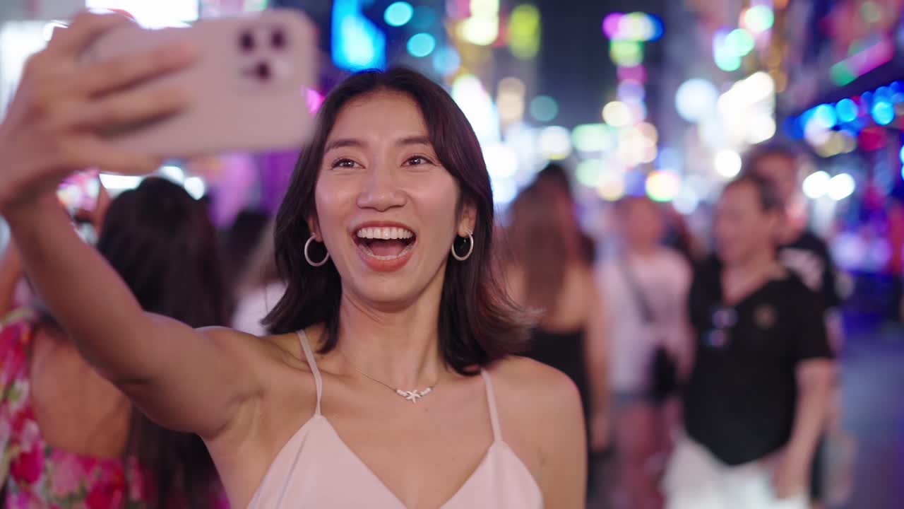 Woman taking a selfie at night in a city street