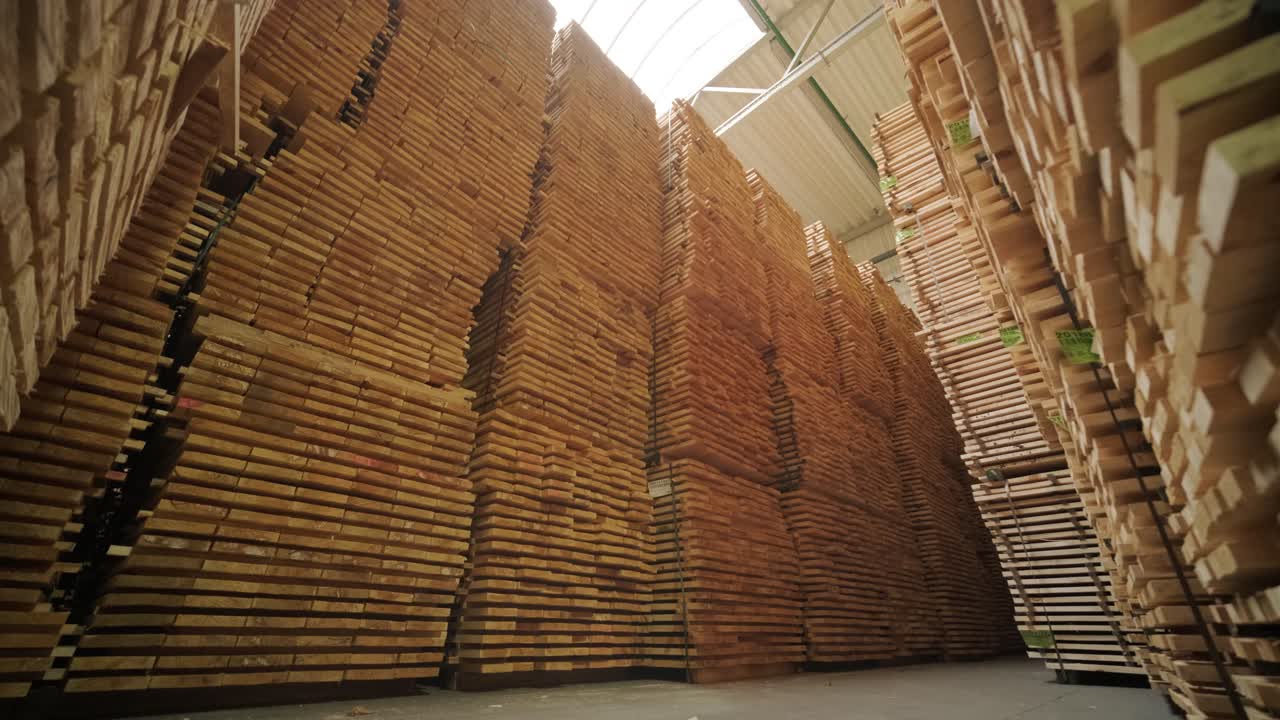Tumpukan Tinggi Papan Kayu Olahan yang Disimpan di Gudang