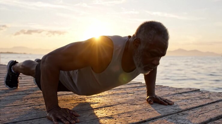 An Inspiring Scene of a Determined Older Man Performing Push-Ups on a Scenic Pier at Sunrise, Emphasizing Strength, Discipline, and Enjoyment of Nature