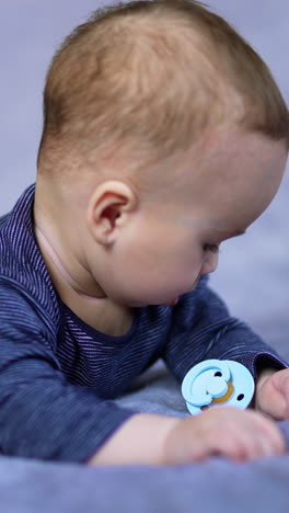 baby lying on tummy with pacifier