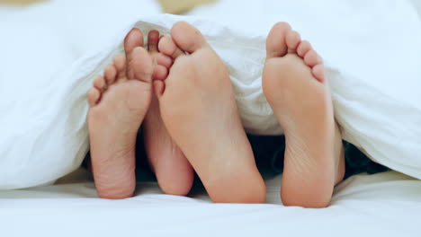 couple, feet and relax in bed together on holiday