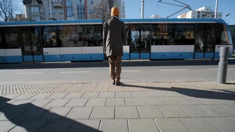 visually impaired man crossing the road with his stick with the help of tactile pedestrian sidewalk for the visually impaired in the city.