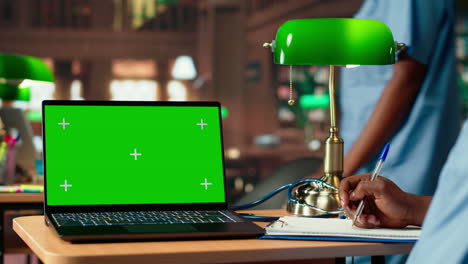 african american male nurse studies anatomy textbooks next to green screen