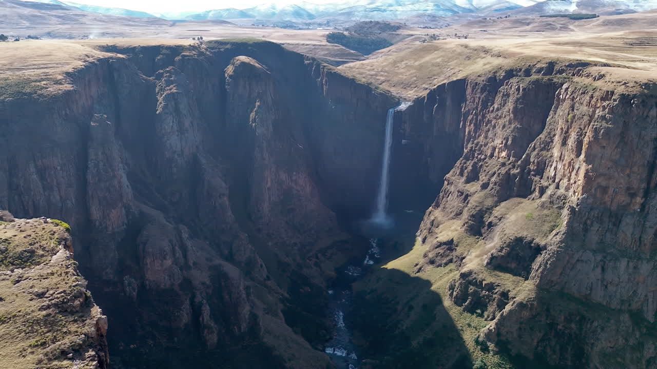 Vista aerea con drone delle Cascate Maletsunyane che si gettano in un canyon profondo negli altopiani del Lesotho, circondate da scogliere aspre e vasti paesaggi montani.