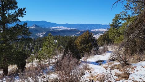 Pico-De-Montaña-Cubierto-De-Nieve-Y-Bosque-Durante-La-Temporada-De-Invierno-Con-Un-Hermoso-Paisaje-Montañoso-De-Fondo