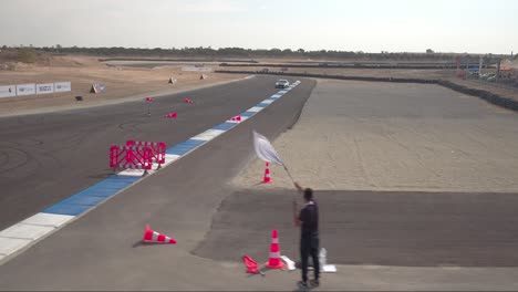 white chevrolet camaro crossing the finish line on a race track