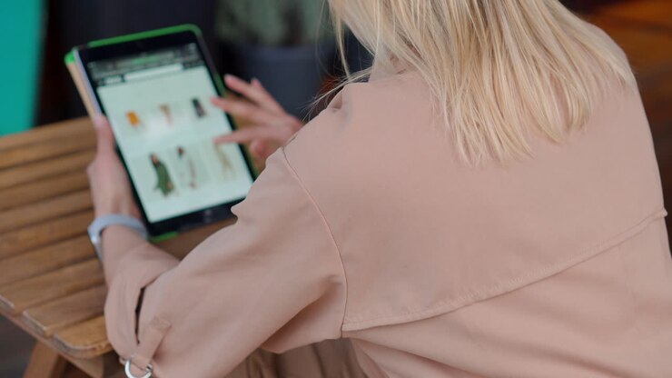 Woman Shopping Online for Clothing at Cafe