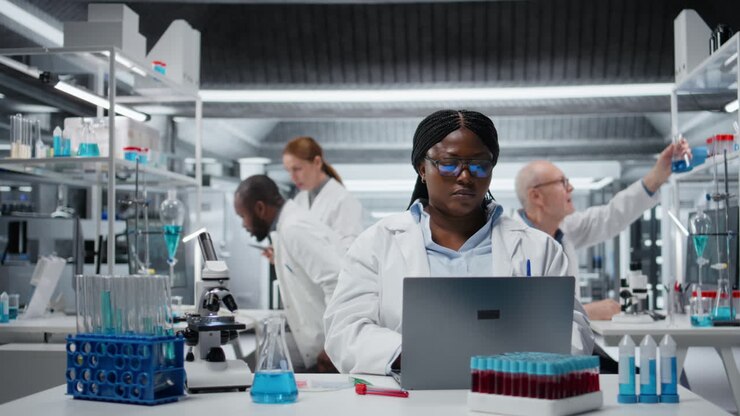 Smiling cytotechnologist works on laptop in lab, studying genomics