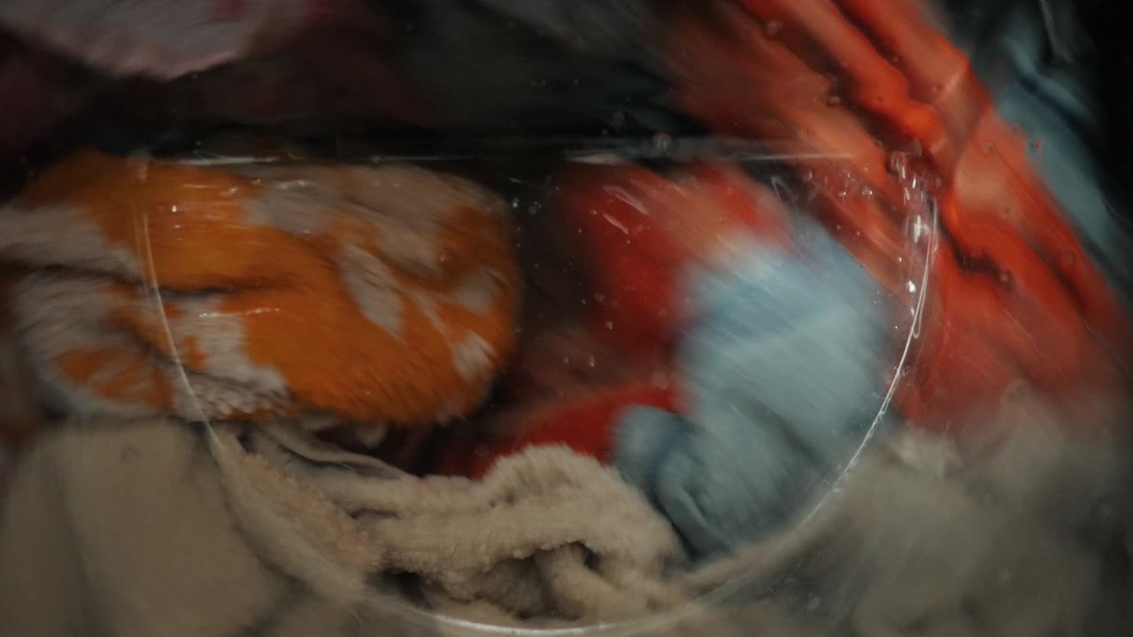 primer plano de cosas de colores y toallas de lavado en la lavadora