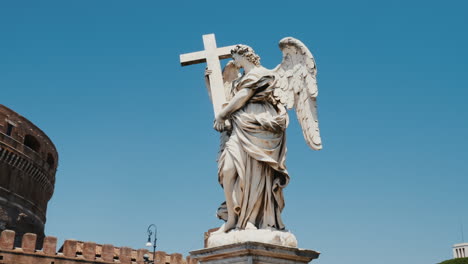 tiro de steadicam: estatua de un ángel con una cruz en el fondo castel santangelo y bandera de la unión europea