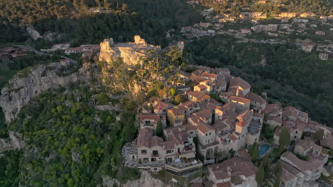 フランス、夕暮れ時にきらめく地中海を見下ろす歴史あるエズ村
