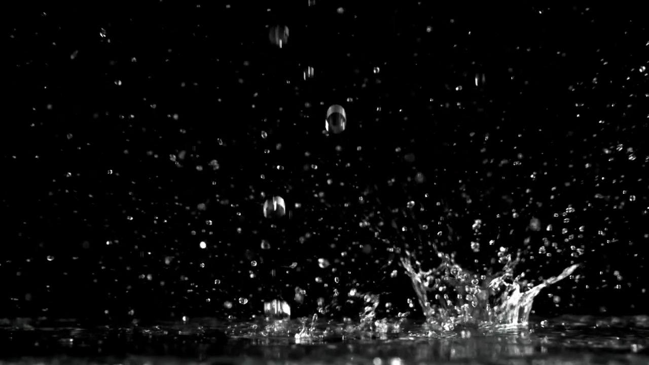 Slow Motion Water Drops Splashing on a Dark Surface