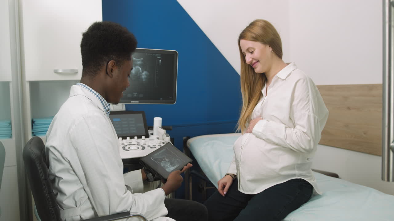 Medico mostra ecografia a donna incinta