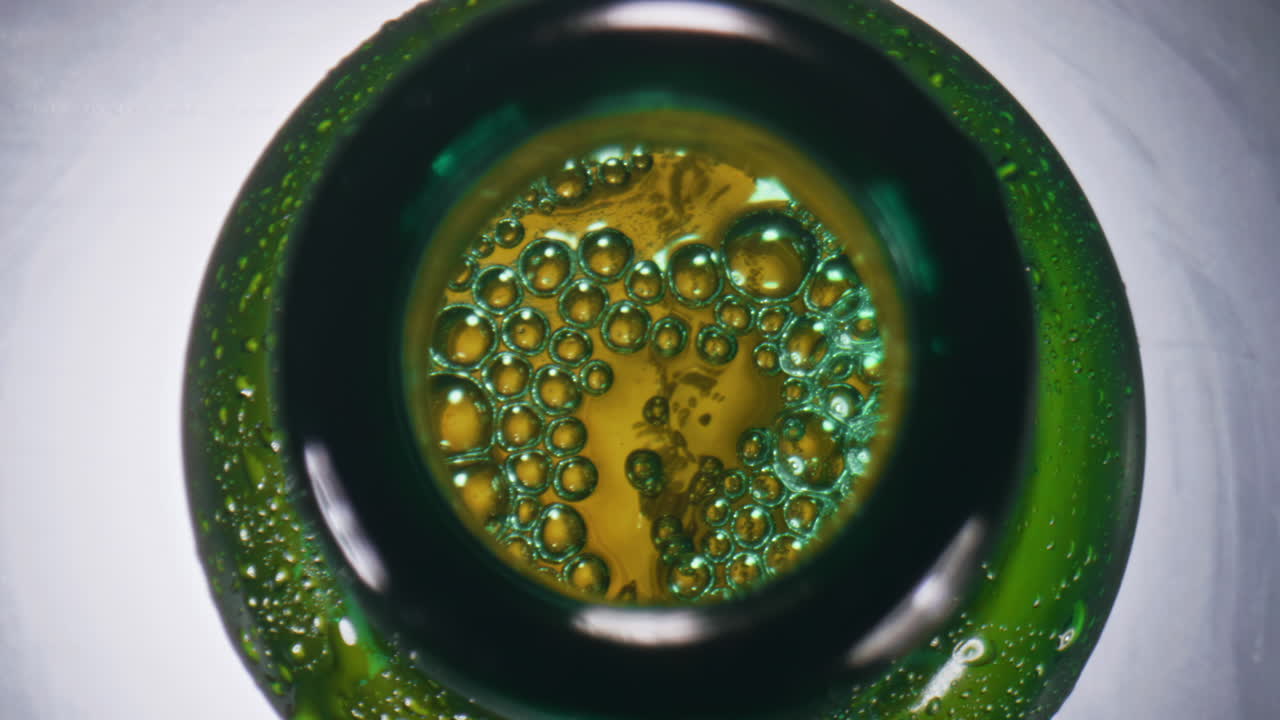 vaso de cerveza efervescente de primer plano. licor alcohólico burbujeando dentro de la botella de vidrio