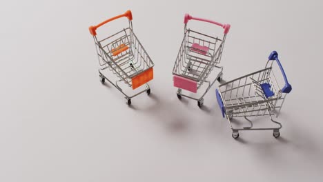 high angle view of three empty shopping trollies on white background with copy space