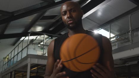 portrait shot of male basketball player on court throwing ball from hand to hand