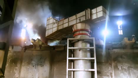 metal scrap burning in furnace at high temperature and huge vacuum sucking the smoke. slow motion.