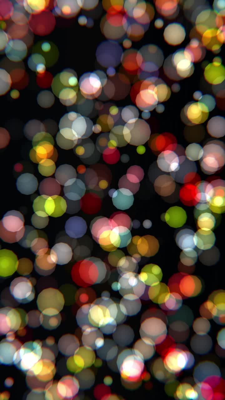 Livlige og tætte flerfarvede bokeh-partikler i rød, gul og grøn, der svæver på en sort baggrund. Sømløs loop perfekt til festligheder, fester og historier på sociale medier