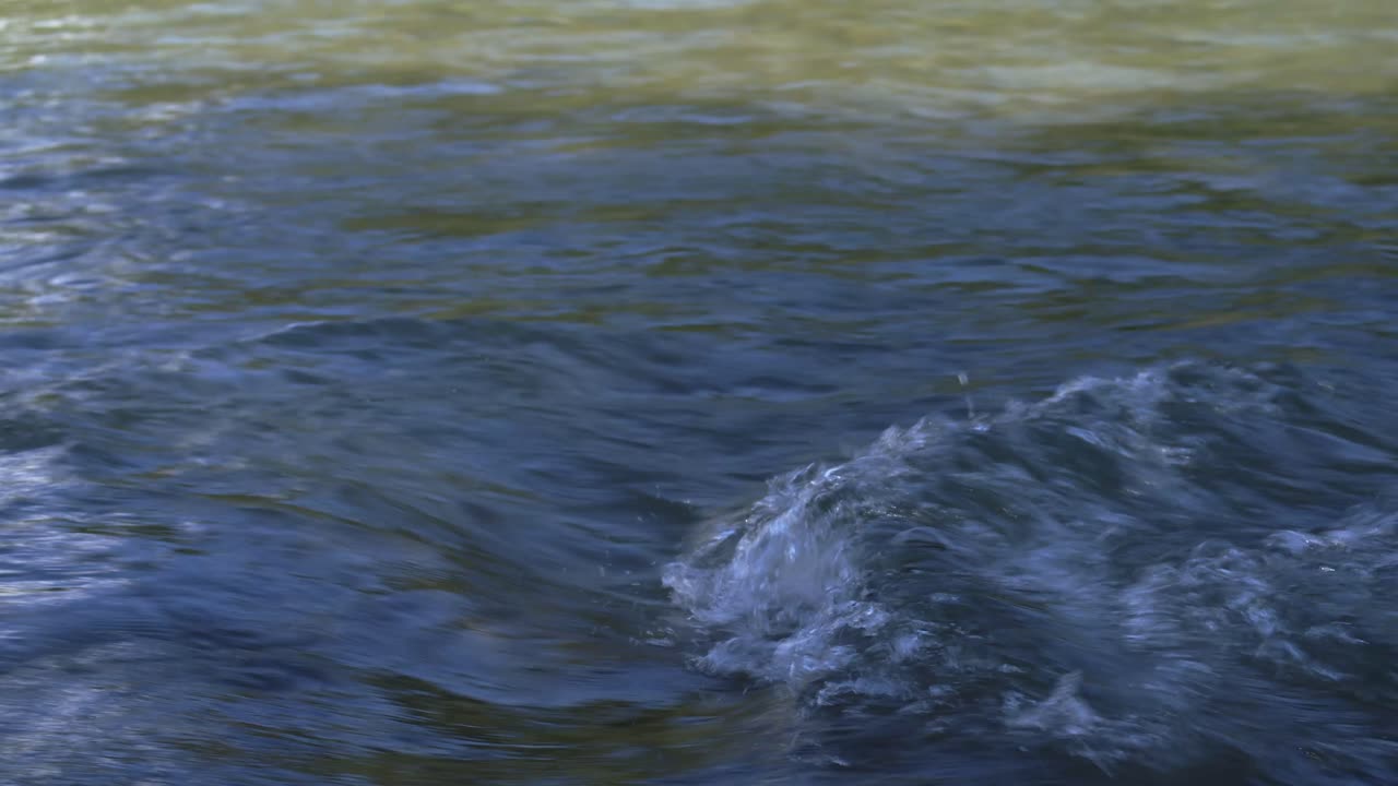 Tight shot of blue-green river water rippling and swirling in natural light. Captured in Tzoumerka.