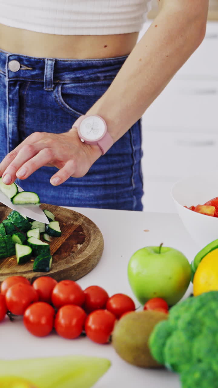 Cooking woman in kitchen. Young woman cooking salad with fresh vegetables in kitchen interior at home Vertical video