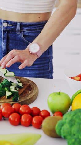 cooking woman in kitchen. young woman cooking salad with fresh vegetables in kitchen interior at home vertical video