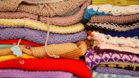 a colorful stack of hand-knitted clothes