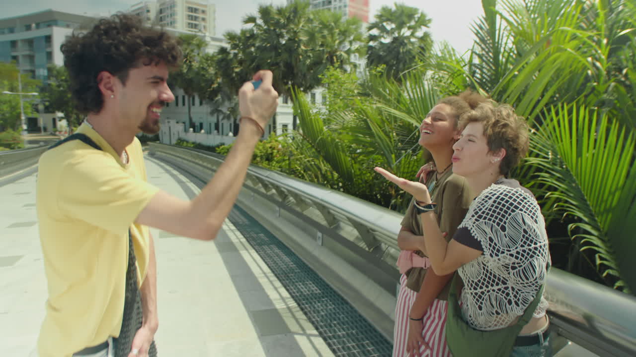 Man Taking Photo of Girlfriends in City on Summer Day