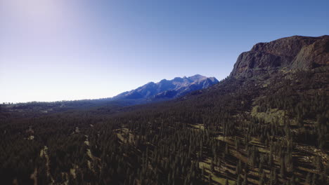 majestic mountains rise above vast forest under clear blue sky
