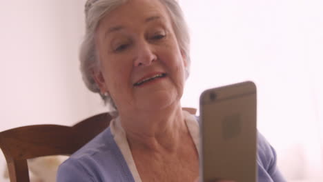 mujer anciana enviando mensajes de texto en teléfono móvil