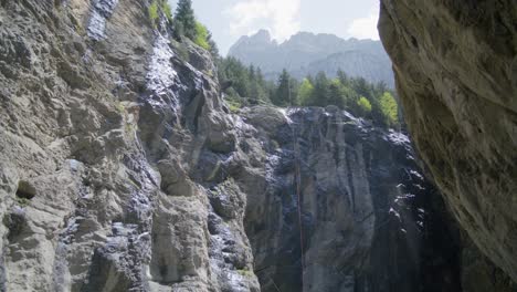 klettern mit seilen an der klippe einer offenen höhle | grindelwald, schweiz, höhle im gletschercanyon, europa, 4k