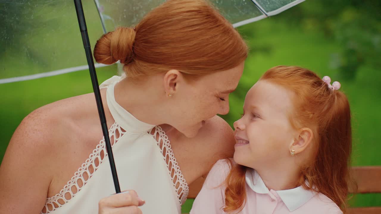 Mother and Daughter under Umbrella in Rain