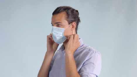 Handsome-brunette-man-putting-on-hygienic-mask