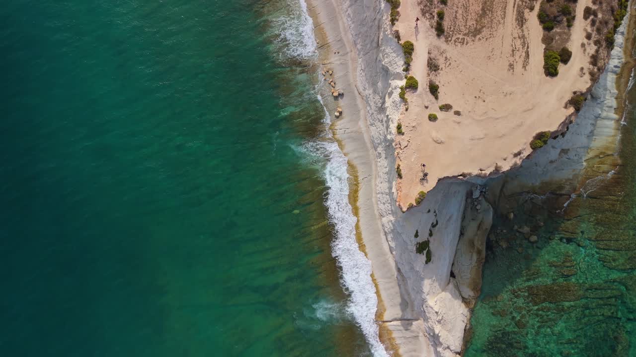 Flying over the steep stretch of the Munxar Path as the crystal clear greenish Mediterranean Sea washes the cliffside in Malta