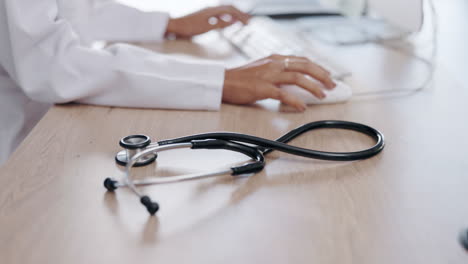 desk, medical tools and woman typing in hospital