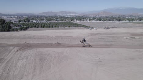 Un-Dron-Observa-Atentamente-La-Meticulosa-Preparación-De-Un-Nuevo-Lote-Por-Parte-De-Un-Cargador-De-Ruedas-Y-Un-Cargador-De-Orugas,-Sentando-Las-Bases-Para-Un-Futuro-Prometedor-Sitio-De-Construcción-De-Viviendas