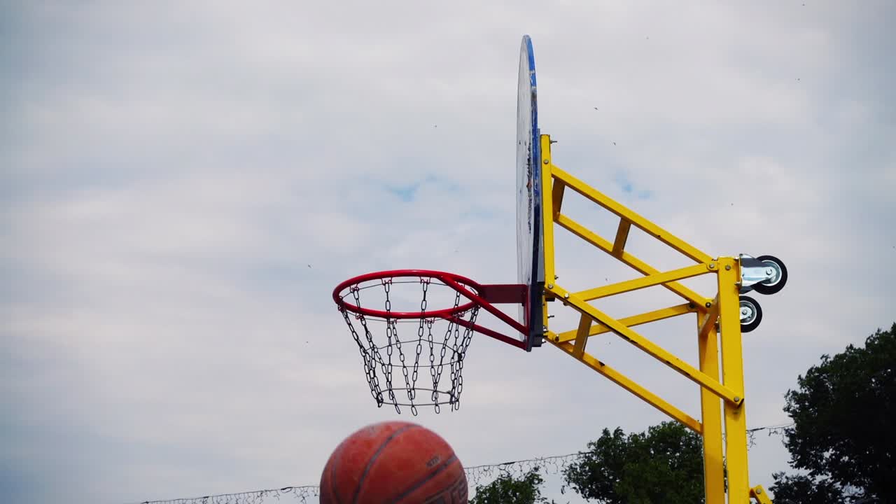 Pallacanestro da strada. La palla vola verso il canestro. Al rallentatore