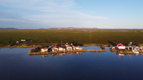 un pueblo en una isla flotante en el lago titicaca peru, montañas en segundo plano