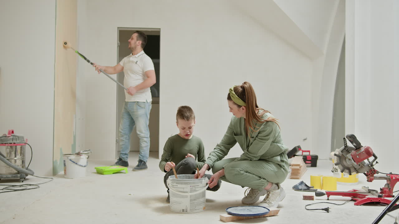 집을 리모델링하는 동안 가족이 함께 방을 칠하는 것