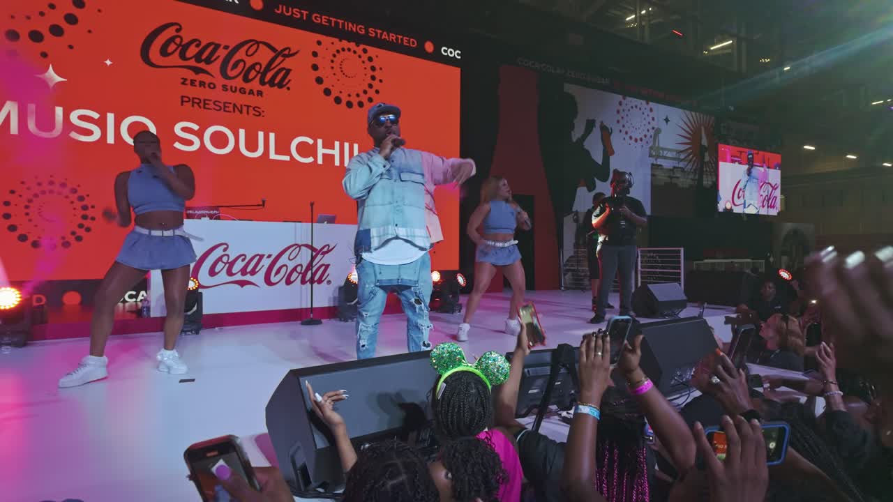 American Singer Soulchild on stage of Essence Festival with many black-skinned fans. Coca Cola sponsoring. Cheering fans in front of show. New Orleans, Louisiana. Close up shot.
