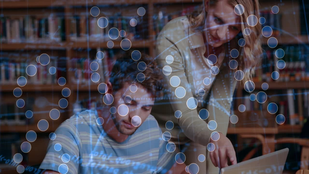 Tutor and student exploring education tech on laptop in library, viewing digital network graphics