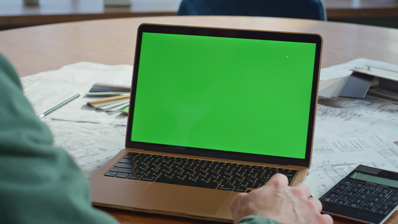 Architect looking chroma key laptop on office desk closeup. Unknown professional