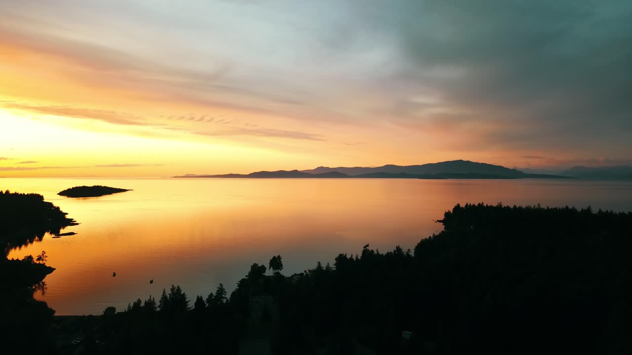 Nedadgående droneoptagelse mod vest af en smuk solnedgang over Vancouver Island